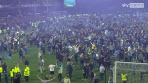 Everton fans evade pitch after the team survived relegation battle