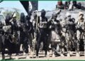 Armed men with a black flag in a forest clearing, used with a report on the killing of a suspected ISWAP commander in Ondo