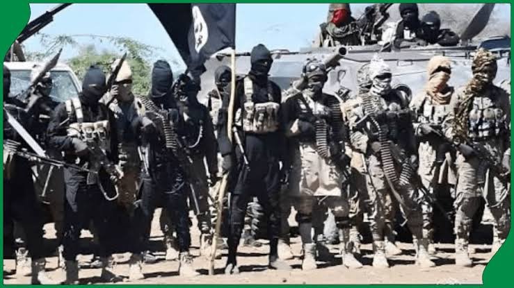 Armed men with a black flag in a forest clearing, used with a report on the killing of a suspected ISWAP commander in Ondo