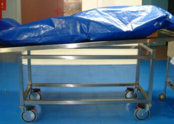 Covered body on mortuary trolley after pastor death