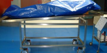 Covered body on mortuary trolley after pastor death