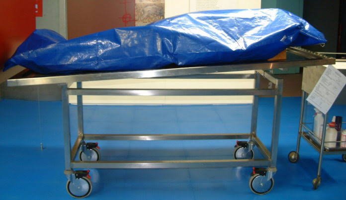 Covered body on mortuary trolley after pastor death